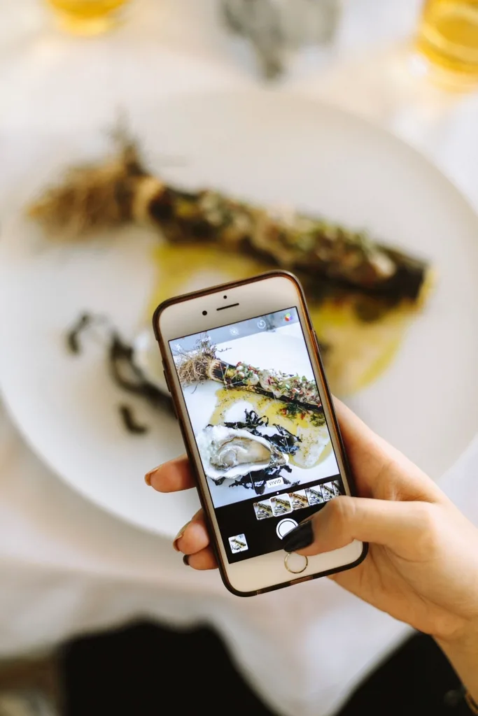 Phone held up to photograph a food and drink setup while making social content